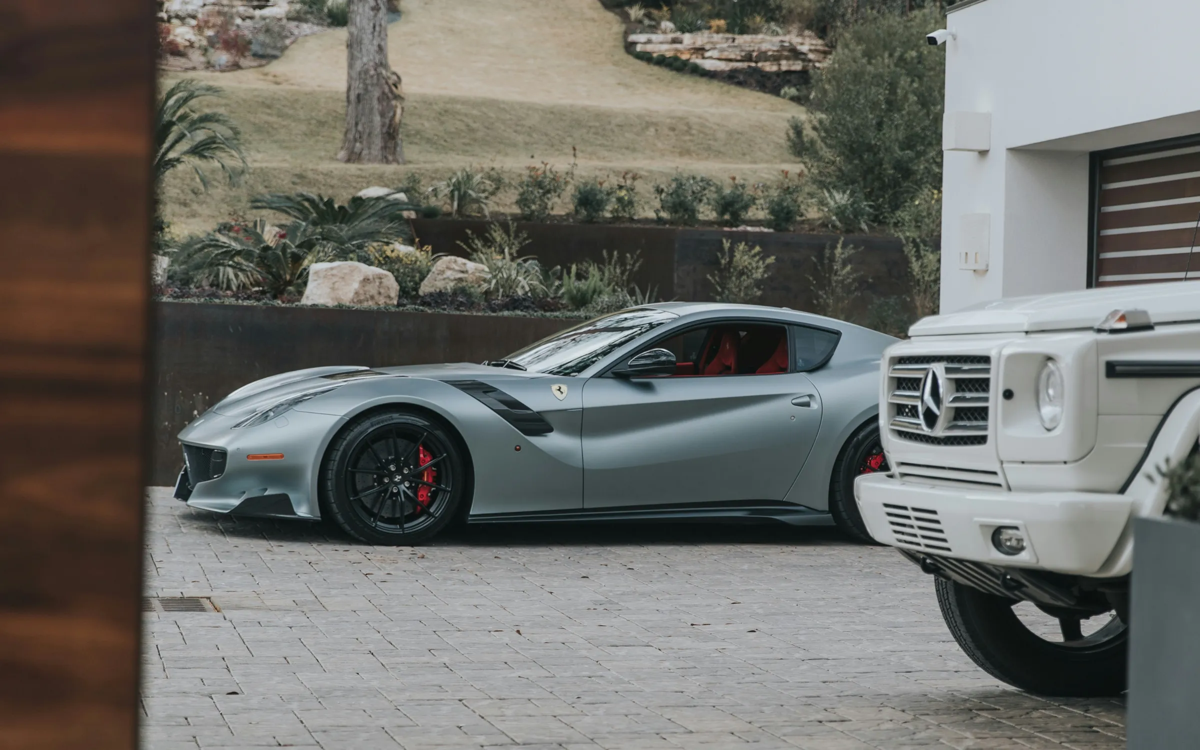 Silver sports car parked side-on across a paved forecourt
